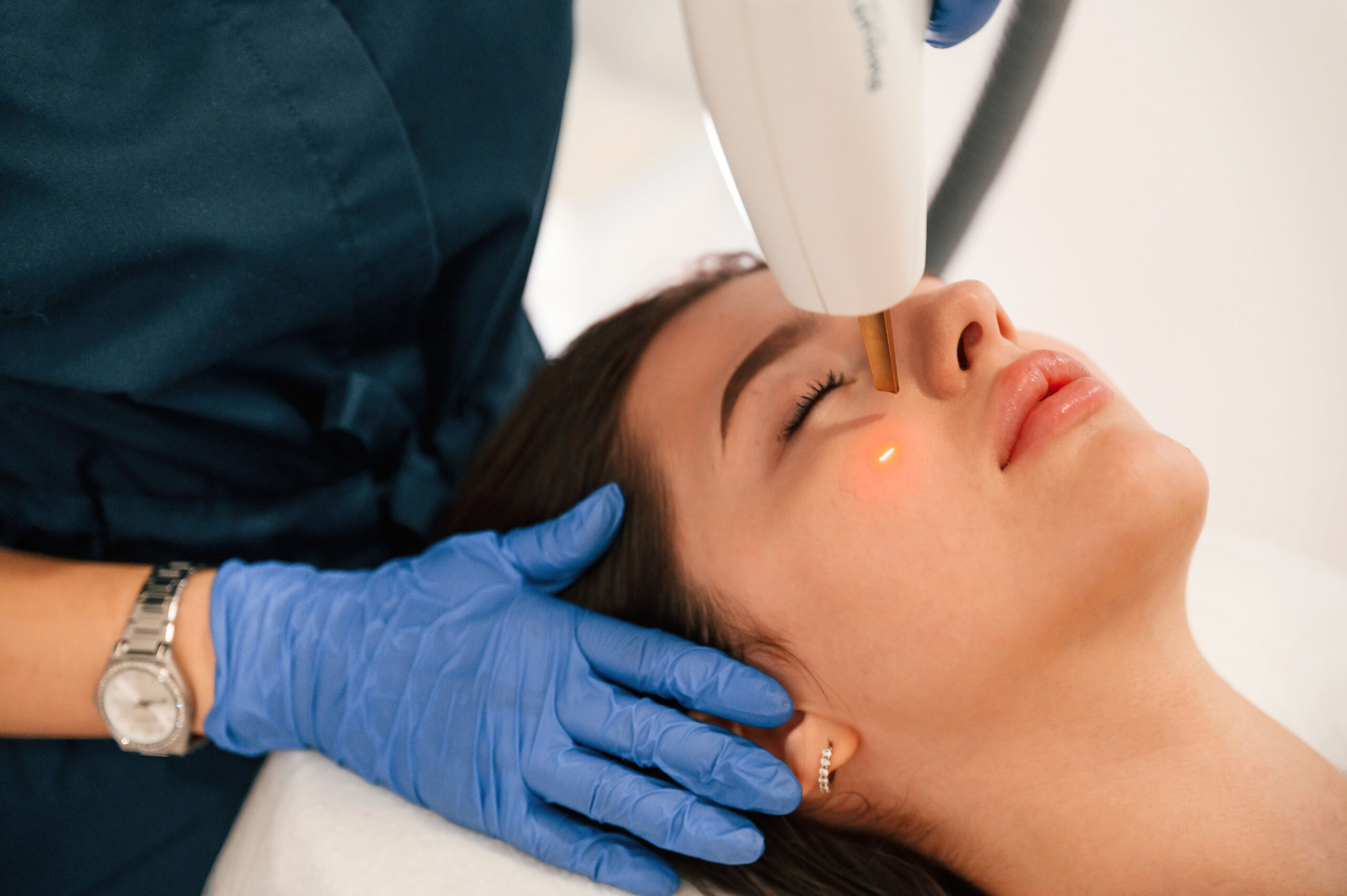 Mulher em clínica fazendo tratamento de laser no rosto.